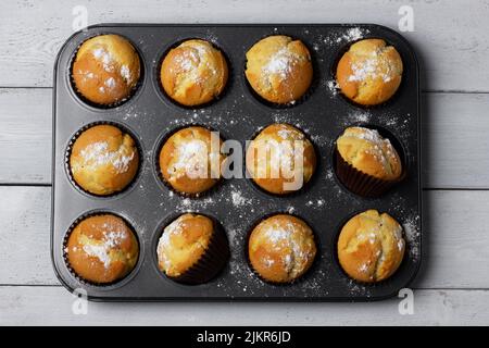 Backblech mit gebackenen Muffins auf weißem Hintergrund. Stockfoto