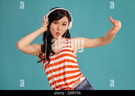 Studiofoto eines wunderschönen Teenagers, das auf einem blauen Hintergrund posiert. Stockfoto