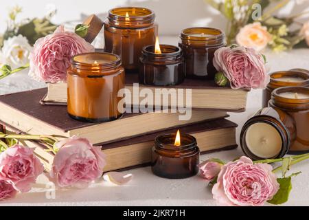 Ein Set verschiedener Duftkerzen in braunen Glasgefäßen. Handgemachte Duftkerze. Sojalkerzen brennen in einem Glas. Aromatherapie und entspannen Sie sich im Spa und zu Hause. Feuer in braunem Glas. Stockfoto