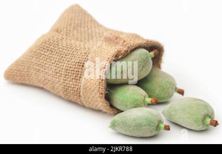 Grüne Mandel in Jutebeutel auf weißem Hintergrund Stockfoto