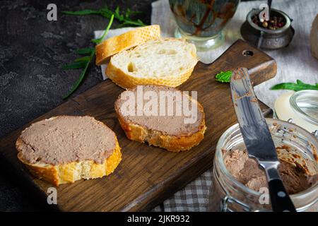 Sandwich mit Hühnerleber-Pastete auf dunklem Hintergrund Stockfoto