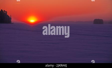 Aufgehende Sonne bricht in Eiskristallen in der Luft auf dem Suvasvesi-See, Vehmersalmi, Finnland, 2022-01-10 09:27 +02. Temperatur -23 Grad, Wind N 2 m/s. Stockfoto