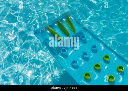 Klare blaue Sommerliegen schweben auf einem geriffelten Swimmingpool Stockfoto