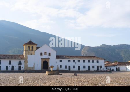 Der Hauptplatz der Villa de Leyva mit Kopfsteinpflaster und der historischen Kirche der Villa de Leyva sowie kolonialen Architekturen Stockfoto