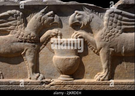 Ein paar Greifen greifen eine Urne. Römische Skulptur auf einem Sarkophag oder einer Grabkiste in der Nekropole von Manastirine, einem Friedhof außerhalb der Mauern der antiken griechischen und römischen Stadt Salona, in Solin bei Split in Dalmatien, Kroatien. Stockfoto