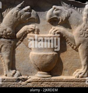 Greifen mit ihren Adlerköpfen und Krallen. Römische Skulptur auf einem Sarkophag oder einer Grabkiste in der Nekropole von Manastirine, einem Friedhof außerhalb der Mauern der antiken griechischen und römischen Stadt Salona, in Solin bei Split in Dalmatien, Kroatien. Stockfoto