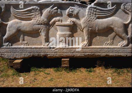 Zwei Greifen, ihre Krallen greifen eine Urne. Auf einem römischen Sarkophag oder einer Grabkiste in der Nekropole von Manastirine, einem Friedhof außerhalb der Mauern der antiken griechischen und römischen Stadt Salona, in Solin bei Split in Dalmatien, Kroatien. Stockfoto