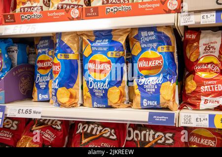 Walkers Chips bereit gesalzen Geschmack, Käse & Zwiebel Geschmack, 6 Beutel auf einem englischen Supermarkt Regal, England, Großbritannien Stockfoto