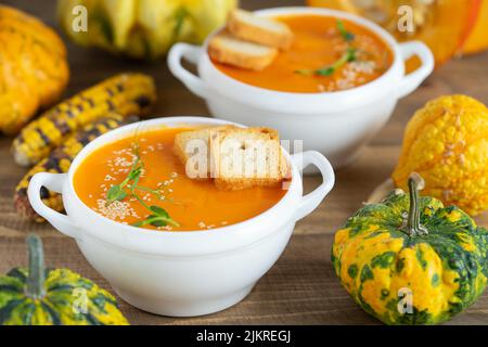 Kürbiscremesuppe mit Croutons auf Holzhintergrund. Stockfoto
