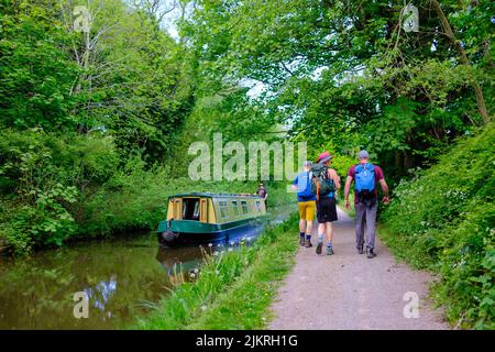 07.05.22 - Spaziergänger passieren ein Kanalboot am Ufer des Monmouthshire und Brecon Kanals, Llanfoist, Abergavenny Stockfoto