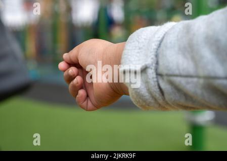 Nahaufnahme der ausgestreckten Hand eines kleinen Kindes, die nach etwas oder jemandem greift. Stockfoto