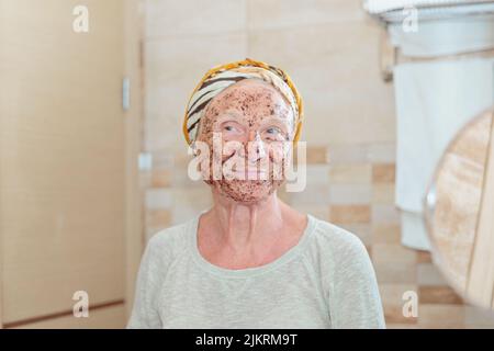 Ältere Frau, die sich um ihr Gesicht kümmert Stockfoto