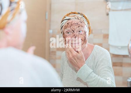 Ältere Frau, die sich um ihr Gesicht kümmert Stockfoto