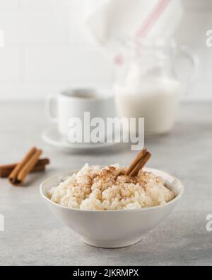Skandinavischer Reisbrei in einer Schüssel mit Zimt. Gesundes Frühstück. Stockfoto