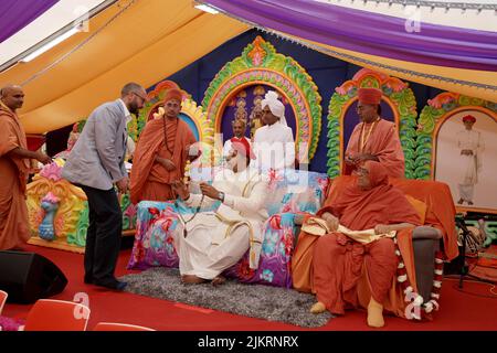 ANDREW Dickey, DIRECTOR of Precious Metals in der Royal Mint, präsentiert Vertreter des Shree Swaminarayan Mandir, Acharya Maharaji Shree Kooshalendra Prasdji, mit einer Lakshmi-Bar und der neu veröffentlichten Ganesh-Bar während einer Zeremonie im kürzlich eröffneten Tempel in Oldham, Greater Manchester. Bilddatum: Mittwoch, 3. August 2022. Stockfoto