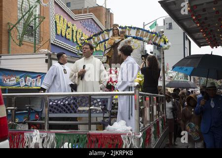 Priester führen eine Prozession vor der Our Lady of Mount Saint Carmel Church beim jährlichen Giglio Feast in Williamsburg, Brooklyn, New York. Stockfoto