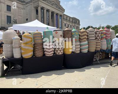 Wunderschön gefertigte Strohkörbe und Hüte können von einem Händler auf einer Kunsthandwerksmesse vor dem Brooklyn Museum am Eastern Parkway in Brooklyn, New York, verkauft werden. Stockfoto