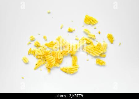 Zerknitterte Chips zerknüllt, verstreute Kartoffel-Snack-Stücke isoliert auf weißem Hintergrund Stockfoto