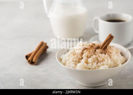 Skandinavischer Reisbrei in einer Schüssel mit Zimt. Gesundes Frühstück. Stockfoto