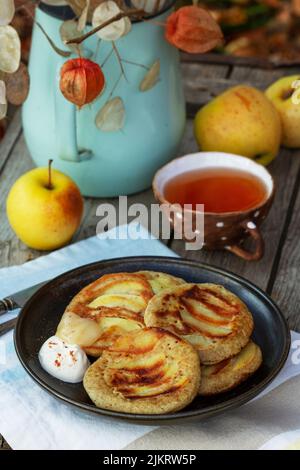 Pfannkuchen mit Vollkornbrot, serviert mit Tee im Garten. Rustikaler Stil. Stockfoto