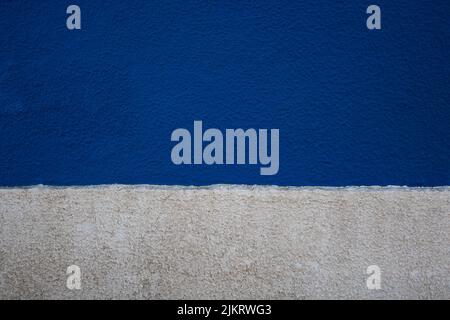 Alte Beton raue Wand Textur in zwei horizontalen Streifen von blauen und weißen Farben lackiert. Abstrakter Hintergrund mit leerem Platz für Text Stockfoto