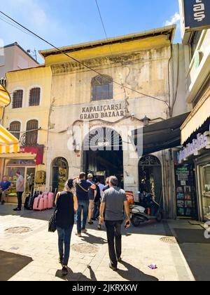 Istanbul, Türkei - 14. Juli 2022: Touristen, Männer und Frauen, Rückansicht, beim Gang in den Großen Basar am Kurkculer-Tor. Außenansicht des Grand Ottoman Stockfoto