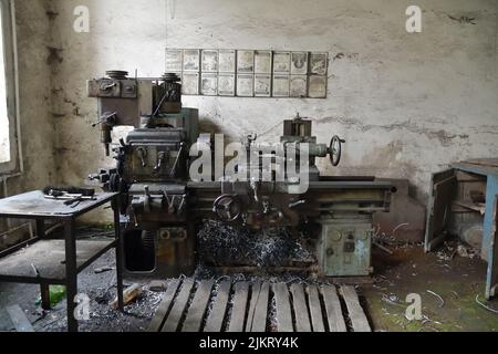 Alte sowjetische Drehmaschine in der Fabrik. Drehmaschine für die Metallbearbeitung. Herstellung schwerer Maschinen. Maschine zum Fräsen von Metall. Sicherheitsanweisungen Stockfoto
