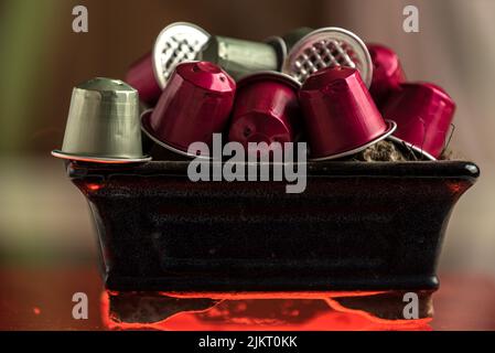 Kaffeekapseln auf einem Tonbehälter mit rotem Licht Stockfoto
