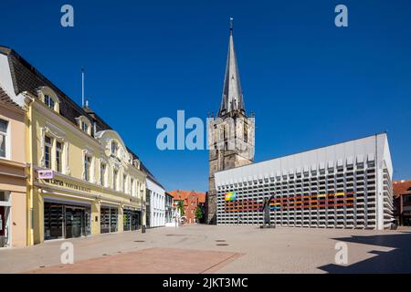 Deutschland, Ahaus, Westmuensterland, Münsterland, Westfalen, Nordrhein-Westfalen, NRW, Katholische Marienkirche am Marktplatz, der Kirchturm stammt aus der historischen Kirche und das Kirchenschiff wurde als Betonbau von Erwin Schiffer befestigt, vor der Skulptur 'der Mahner' von Hilde Schuerk frisch, Verließ das Wohn- und Geschäftshaus der Familie Beckering Stockfoto