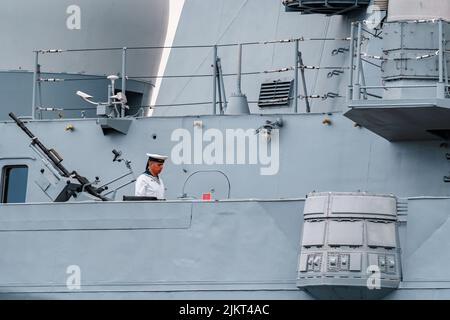 Russland, St. Petersburg, 31. Juli 2022: Der Militärsegler eines Kriegsschiffes steht an Deck eines Schiffes in der Nähe einer Waffe, er ist in einer festlichen weißen Uniform gekleidet Stockfoto