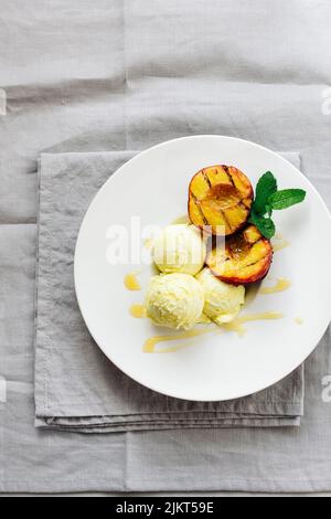 Gegrillte Pfirsiche und Zitroneneis mit Honig. Stockfoto