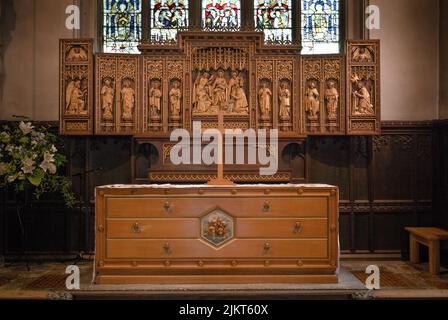 Der Altar und die kunstvoll geschnitzte hölzerne Altarwand in der St. Mary's Church in Petworth, West Sussex, Großbritannien. Stockfoto