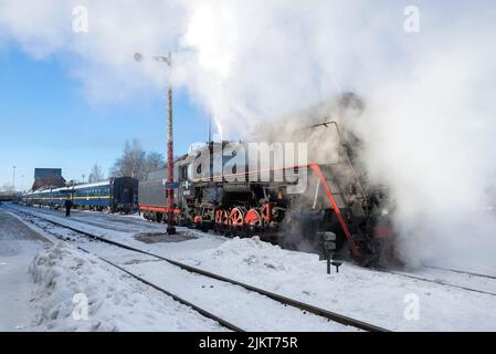 SORTAVALA, RUSSLAND - 10. MÄRZ 2021: Alte Dampflokomotive LV-0522 und touristischer Retrozug des 'Ruskeala Express' auf dem Bahnhof Sortavala bei einem frostigen Marsch Stockfoto