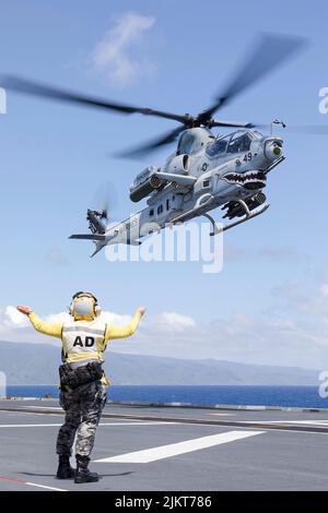 Pazifik, Usa. 01. August 2022. Ein US Marine Corps AH-1Z Viper Angriffshubschrauber wird signalisiert, auf dem Flugdeck des Canberra-Klasse-Landungshubschraubers HMAS Canberra der Royal Australian Navy während eines amphibischen Angriffs am 28. Juli 2022 vor der Küste von Hawaii, USA, zu landen. Quelle: Seemann Matthew Lyall/US Navy/Alamy Live News Stockfoto