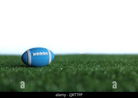 Selektives Fokusbild von Rugby-Ball auf Rugby-Pitch-Gras isoliert auf weißem Hintergrund Stockfoto