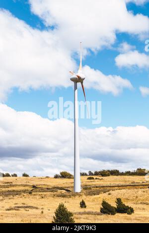 Ein natürlicher Blick auf eine Windmühle auf einem riesigen Trockenland unter einem bewölkten Himmel Stockfoto
