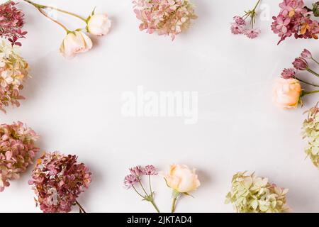 Herbst kreative Komposition Rosen, Hortensien Blumen auf grauem Hintergrund. Herbst, Herbsthintergrund. Flach liegend, Draufsicht, Kopierbereich Stockfoto