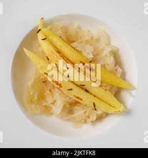 Fingerförmige Kartoffelknödel auf Sauerkraut auf einem Teller Stockfoto