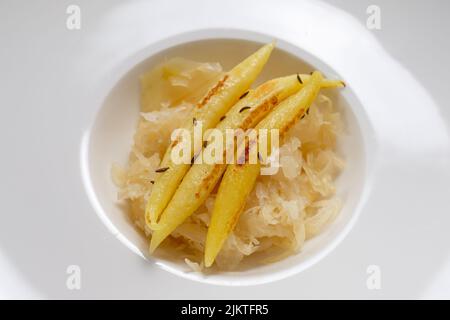 Fingerförmige Kartoffelknödel auf Sauerkraut-Gericht in einem Restaurant Stockfoto