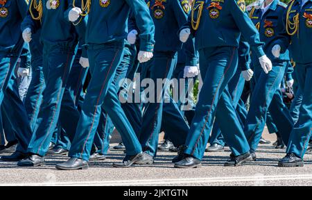 Eine Gruppe junger Menschen, die in Polizeiuniformen gekleidet sind, marschieren eine Straße entlang. Der 9. Mai ist jährlicher Feiertag des Siegestages. Stockfoto