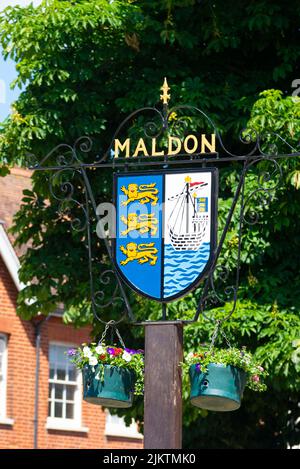 Maldon-Stadtschild mit Stadtwappen mit Löwen und einem Segelschiff an der Ostküste auf dem Fluss Blackwater. Aufhängekörbe Stockfoto