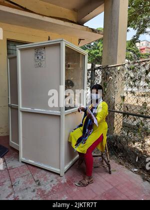 Bangalore, Karnataka, Indien-11. April 2022: Nahaufnahme des Covid- oder Corona-Tests mit dem indischen Mädchen vom Stand des Krankenhauses draußen. Stockfoto