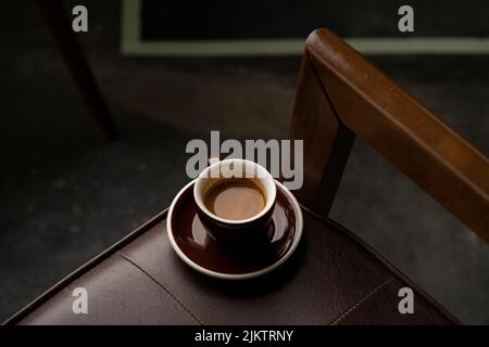 Eine Draufsicht auf eine Tasse Kaffee auf einem Lederstuhl Stockfoto
