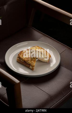 Eine Nahaufnahme von zwei Stücken sandwiches mit französischem Toast auf einem Lederstuhl Stockfoto