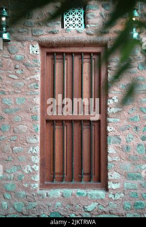 Eine Nahaufnahme eines geschlossenen Holzfensters mit Metallstangen darauf Stockfoto