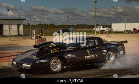 Das Auto wärmt die Reifen vor dem Drag-Rennen mit einer Rauchshow auf. Burnout und Drift an der Startlinie Stockfoto