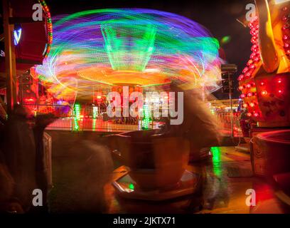 Leichte Spuren von den sich drehenden Teetassen der Kinder und der „Extreme“-Fahrt beim Witney Feast. September 2015 Stockfoto