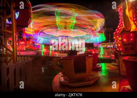 Leichte Spuren von den sich drehenden Teetassen der Kinder und der „Extreme“-Fahrt beim Witney Feast. September 2015 Stockfoto