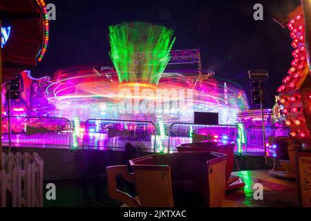 Leichte Spuren von den sich drehenden Teetassen der Kinder und der „Extreme“-Fahrt beim Witney Feast. September 2015 Stockfoto