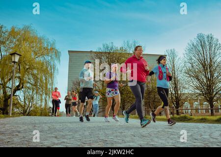 Jogginggruppe läuft durch den Park in München. Sportler trainieren im Frühjahr für die Sommerfigur Stockfoto